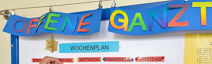 Eine Wochenplan-Tafel mit bunten Zetteln und Beschriftungen in einer Offenen Ganztagsschule.